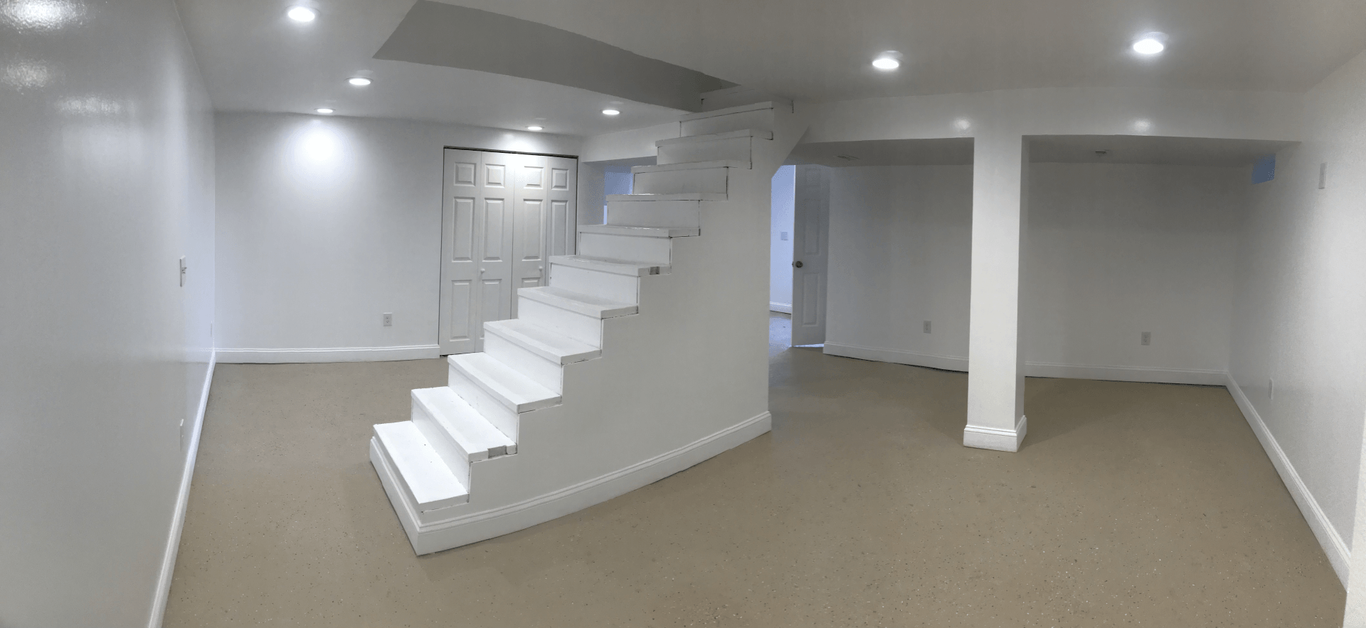 Basement renovation with a custom white staircase
