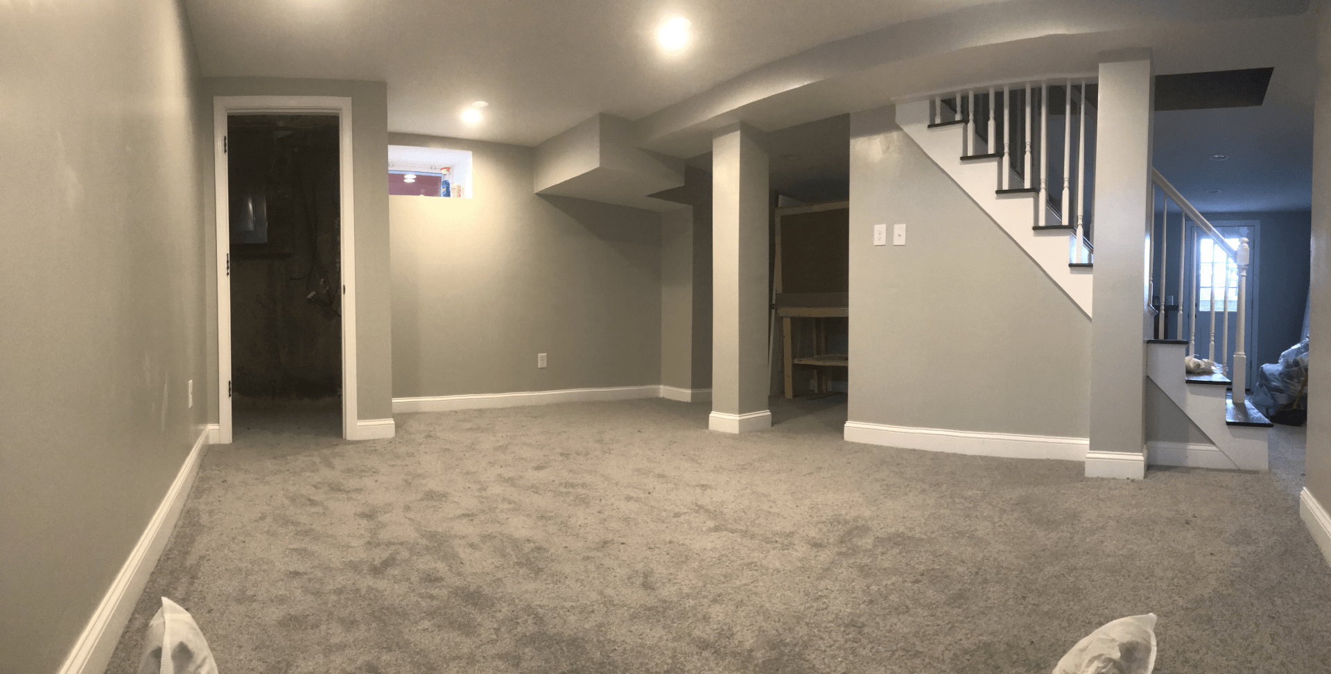 Finished basement with gray walls and beige carpet